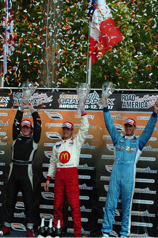 Top Three Hold Up Trophies On Podium
